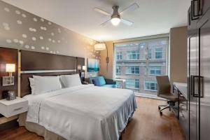 纽约曼哈顿中城时代广场南部惠庭套房酒店的一间卧室配有一张床、一张书桌和一个窗户。