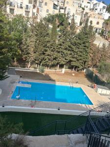 贝纳哈拉菲La estrella de Javi的一座大型蓝色游泳池,位于部分建筑前