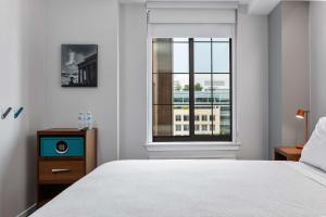 华盛顿Motto by Hilton Washington DC City Center的一间卧室设有一张床和一个窗口