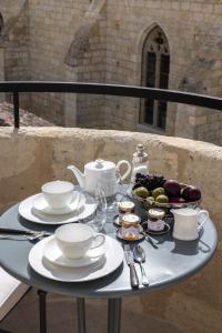 圣艾米隆Hotel Porte Brunet的盘子,杯子和果盘的桌子