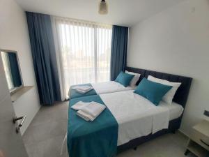 AksuEthica Suite Luxury Houses的一间卧室配有一张带蓝白色枕头的大床