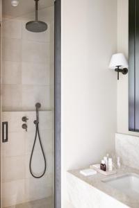 圣艾米隆Hotel Porte Brunet的带淋浴和盥洗盆的浴室