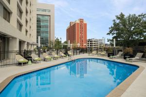 伯明翰Hilton Birmingham Downtown at UAB的一座带躺椅的游泳池和一座建筑