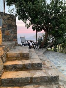 莫什劳斯Petra Nova Villas的庭院设有两把椅子和一张石墙桌子。