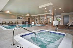 兰辛Hilton Garden Inn Lansing West的一座大型游泳池,在酒店的房间内配有热水浴缸