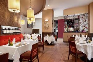 纽约DoubleTree by Hilton New York Downtown的一间设有白色桌椅的餐厅和一间酒吧