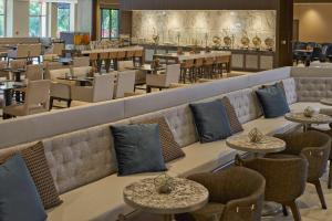 罗利罗利北山希尔顿酒店的一间带桌椅的餐厅和一间酒吧
