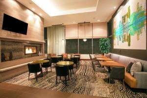 西雅图西雅图市中心希尔顿花园酒店的餐厅设有桌椅和沙发。