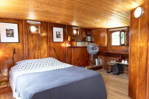 阿维尼翁奥尔西娅船屋的船上的卧室配有一张床和风扇