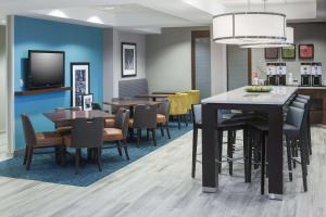 利伯蒂堪萨斯城利伯蒂希尔顿恒庭酒店的一间带桌椅和电视的用餐室