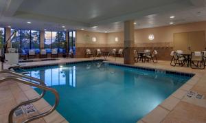 密尔沃基密尔沃基机场希尔顿花园酒店的一座配有桌椅的酒店游泳池