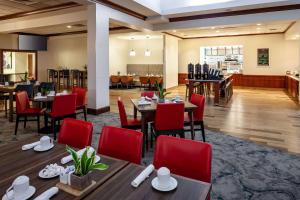 德斯普兰斯芝加哥奥黑尔机场希尔顿花园酒店的餐厅设有木桌和红色椅子