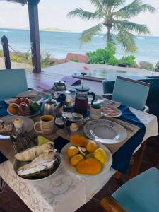 Anse Kerlan维拉索菲亚住宿加早餐旅馆的一张桌子,上面有食物,后面有海洋