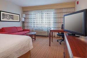 章克申城Courtyard by Marriott Junction City的酒店的客房配有平面电视和床。
