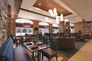 俄克拉何马城俄克拉何马城/布里克顿希尔顿花园酒店的餐厅设有桌椅和窗户。