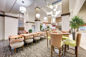 斯普林北休斯顿斯普林希尔顿花园酒店的大型用餐室配有桌椅