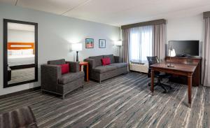 圣路易斯圣路易斯森林公园汉普顿酒店及套房的酒店客房设有书桌和卧室。