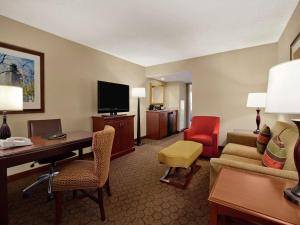 奥斯汀Embassy Suites by Hilton Austin Arboretum的酒店客房设有书桌和客厅。