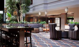 达拉斯Embassy Suites by Hilton Dallas Near the Galleria的酒店大堂设有桌椅