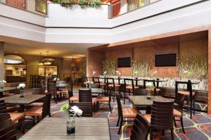 达拉斯Embassy Suites by Hilton Dallas Near the Galleria的一间带桌椅的餐厅和一间酒吧