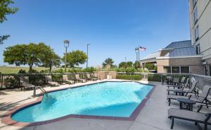 罗阿诺克Hampton Inn & Suites N Ft Worth-Alliance Airport的一座带庭院家具的游泳池和一座建筑