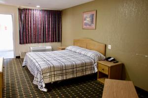 阿林顿Executive Inn of Arlington, Near AT&T Stadium的酒店客房设有床和窗户。