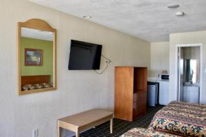 阿林顿Executive Inn of Arlington, Near AT&T Stadium的配有一张床和一台平面电视的酒店客房