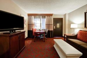 赫恩登Embassy Suites by Hilton Dulles Airport的一间配备有沙发及电视的酒店客房