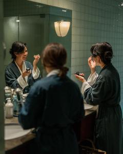 路易斯湖Post Hotel & Spa的把牙齿刷在浴室镜子前的女人
