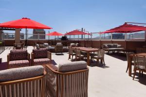 埃尔帕索DoubleTree by Hilton El Paso Downtown的一个带桌椅和红色遮阳伞的庭院