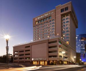 埃尔帕索DoubleTree by Hilton El Paso Downtown的夜间城市街道上的酒店大楼