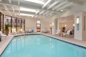 尔湾Embassy Suites by Hilton Irvine Orange County Airport的一座配有桌椅的酒店游泳池