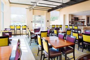 温莎哈特福德北布拉德利国际机场希尔顿花园酒店的用餐室配有木桌和椅子