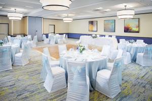 温莎哈特福德北布拉德利国际机场希尔顿花园酒店的宴会厅配有白色的桌子和白色的椅子