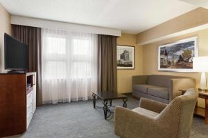诺维DoubleTree by Hilton Hotel Detroit - Novi的一间客厅,客厅配有沙发和电视,位于酒店的房间