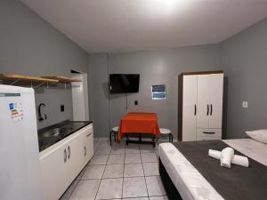 南圣弗朗西斯科Pousada VSC的客房设有带一张床和一张桌子的厨房