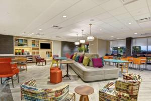 麦迪逊Home2 Suites By Hilton Madison Huntsville Airport的大堂配有沙发和桌椅
