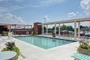 麦迪逊Home2 Suites By Hilton Madison Huntsville Airport的一座配有桌椅的酒店游泳池
