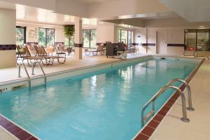 科科莫科科莫希尔顿恒庭旅馆&套房酒店的酒店的大型游泳池配有桌椅