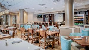 西棕榈滩DoubleTree by Hilton Hotel West Palm Beach Airport的餐厅内带桌椅的用餐室