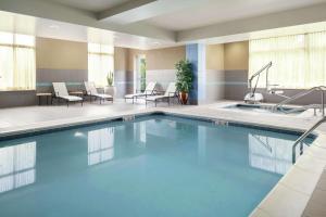 佩里斯堡托莱多/佩里斯堡希尔顿花园旅馆的游泳池位于酒店客房内,配有桌椅