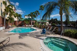 坦帕坦帕易勃尔历史区希尔顿花园酒店的一个带椅子的游泳池,并种植了棕榈树