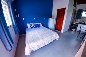 佩尼多Flats 2 Locação Penedo RJ的一间卧室设有一张床和蓝色的墙壁
