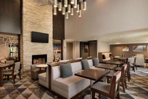 波特兰波特兰机场－希尔顿惠庭套房酒店的酒店大堂设有壁炉和桌椅