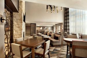 波特兰波特兰机场－希尔顿惠庭套房酒店的一间带桌椅的餐厅和一间酒吧