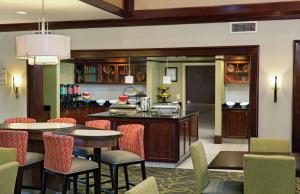 桑兹顿里士满希尔顿惠庭套房酒店 - 机场的厨房以及带桌椅的用餐室。