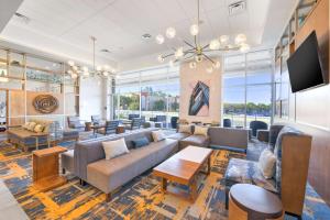 弗里蒙特Hilton Garden Inn Fremont Milpitas的带沙发和桌子的客厅以及窗户。