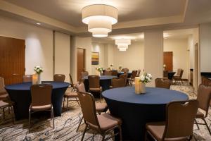 皇后区Hilton Garden Inn Long Island City的一间会议室,配有两张桌子和椅子,还有一组