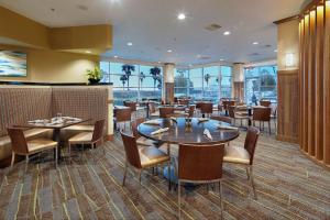 布里斯班DoubleTree by Hilton San Francisco Airport North Bayfront的餐厅设有桌椅和窗户。