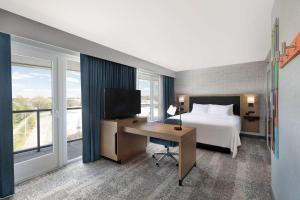沃特敦Hampton Inn & Suites Watertown Boston, Ma的酒店客房配有一张床和一张书桌及一台电视